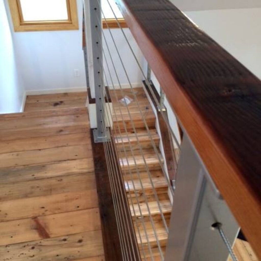 Close-up of thin stainless steel cables in a railing system showing high transparency and light flow.