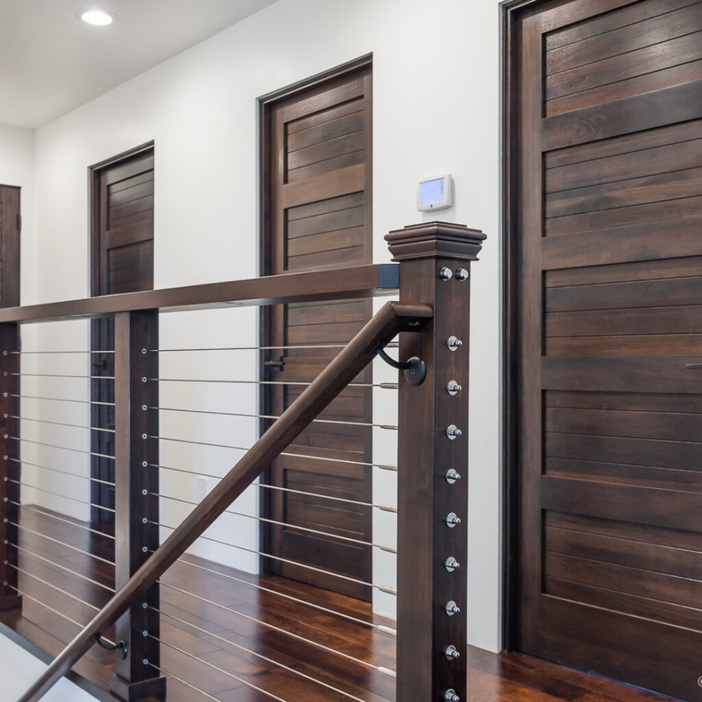 cable railings in front of rooms with wood doors