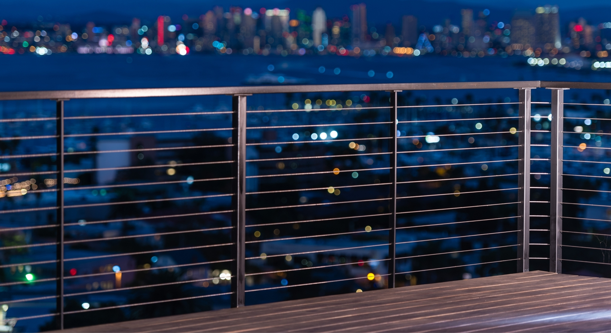 Stainless steel railings along a space overlooking the city at night